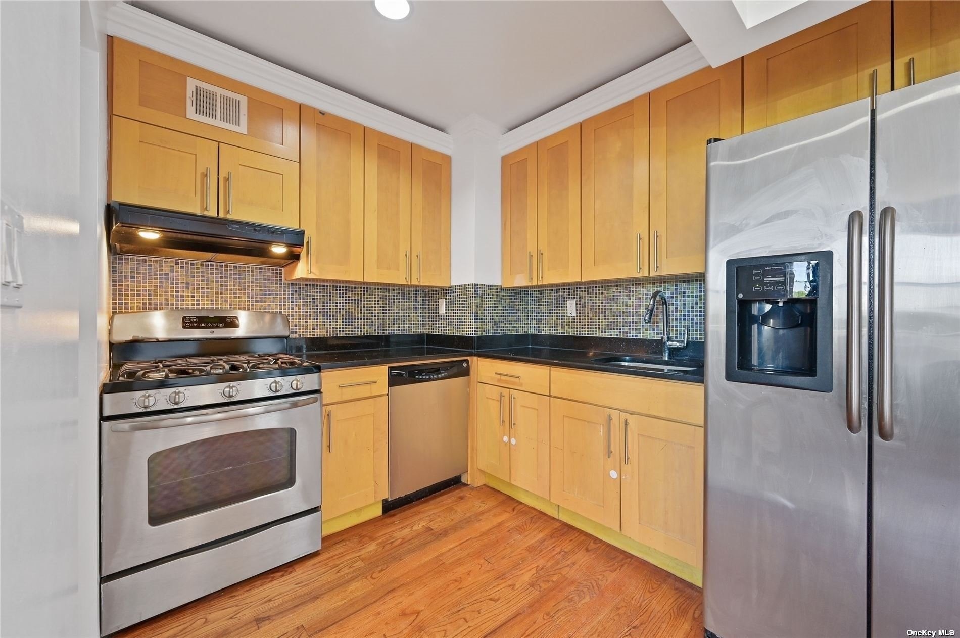 a kitchen with stainless steel appliances granite countertop a stove a refrigerator and a sink