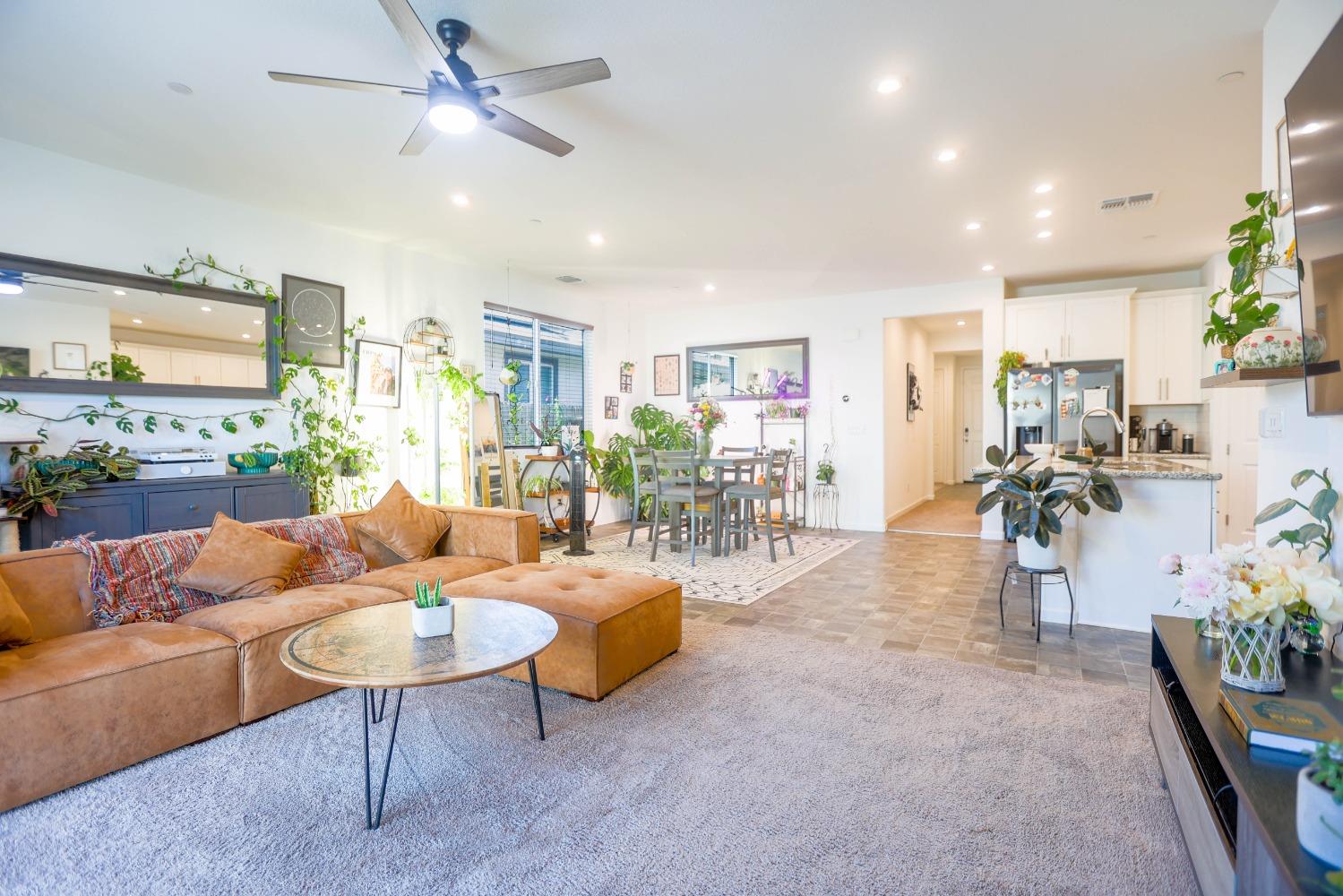 a living room with furniture kitchen view and a large window