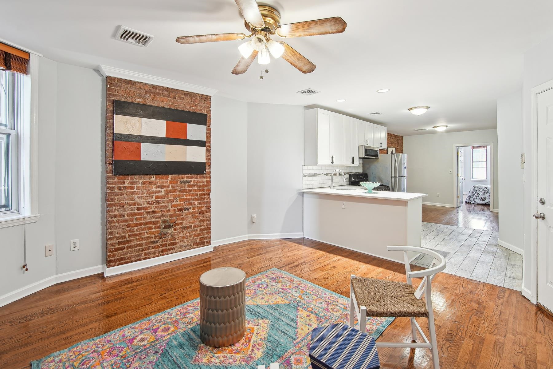 a kitchen with a sink dishwasher a stove and a dining table with wooden floor