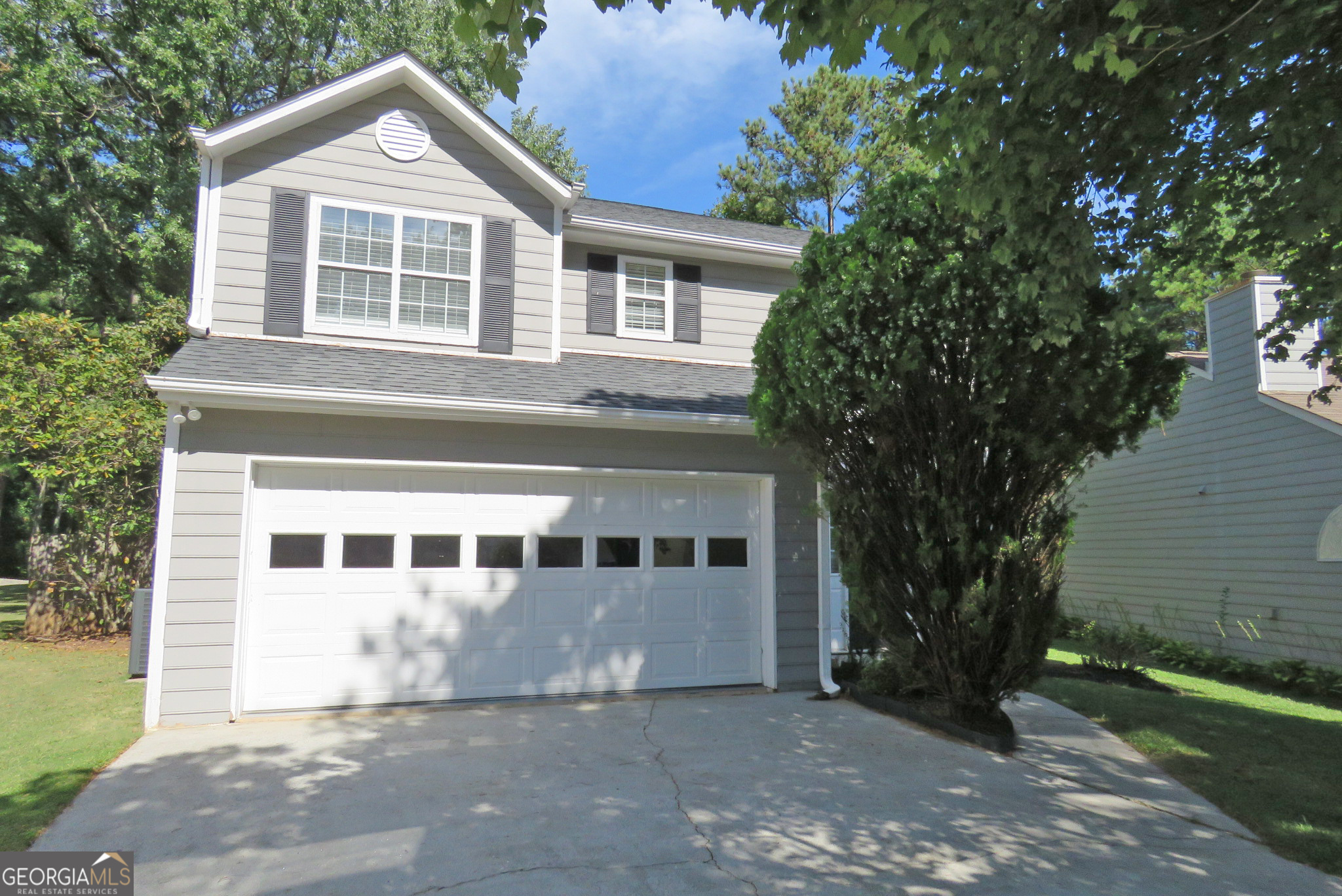 a front view of a house with a garden