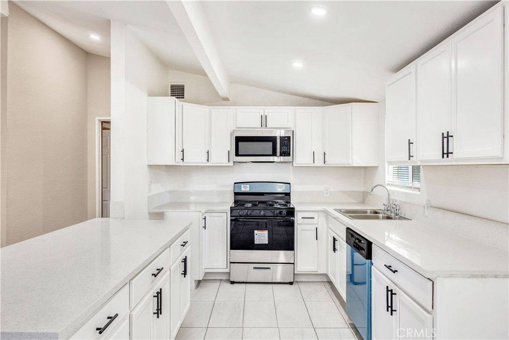 a kitchen with granite countertop white cabinets and white appliances