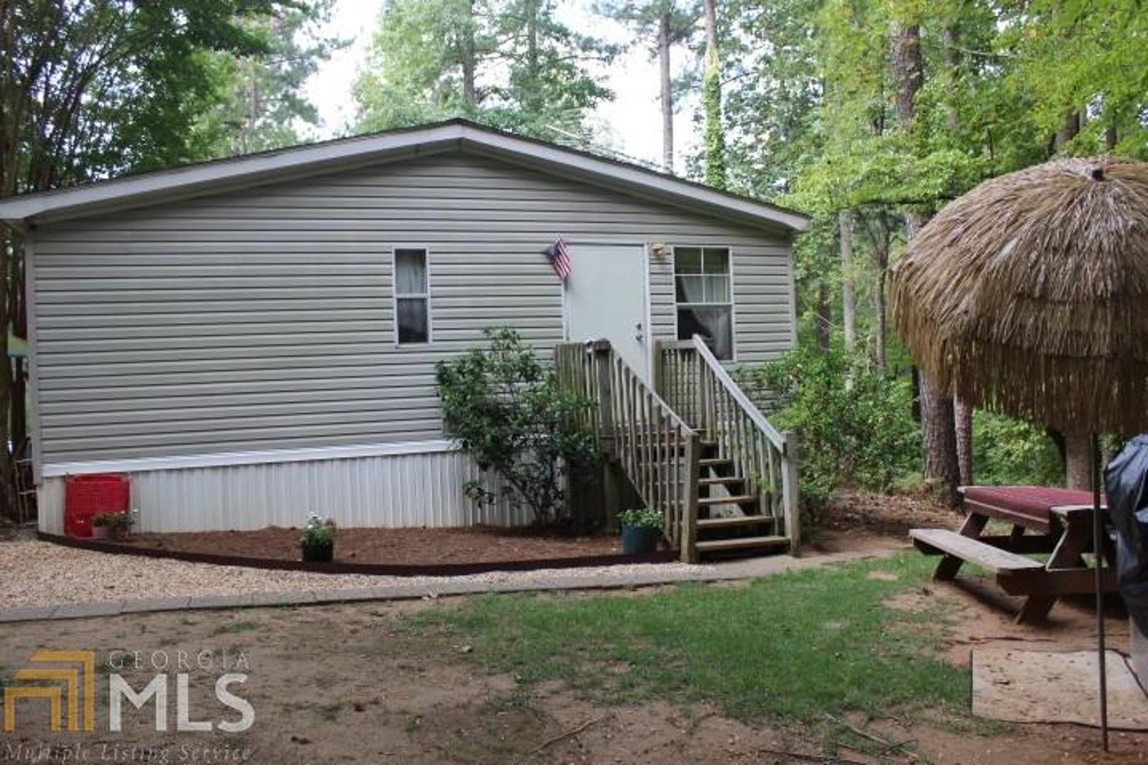 a view of a house with backyard and sitting area