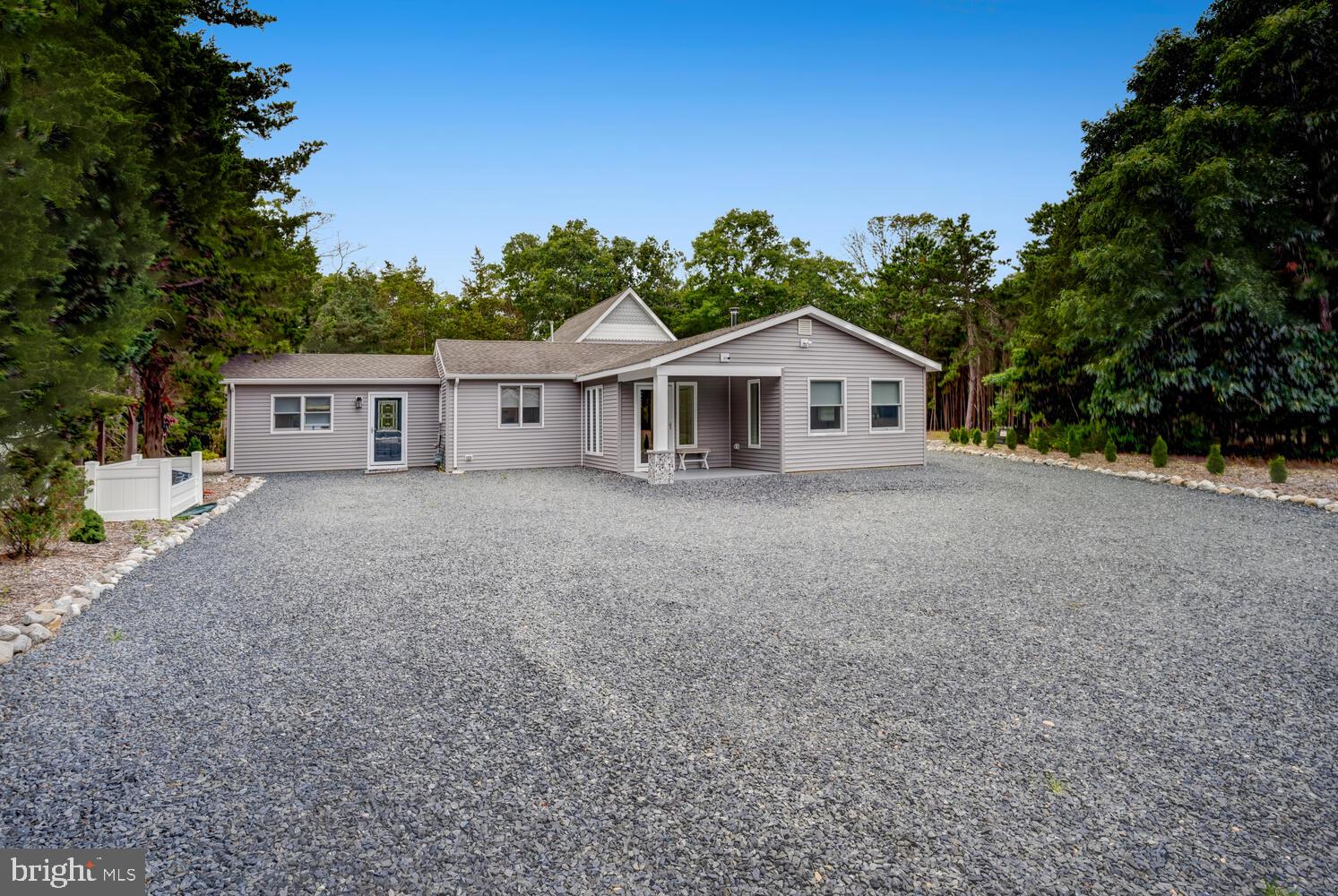 a front view of a house with a yard and trees