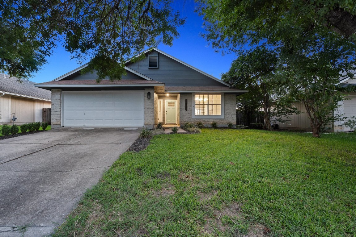 a front view of a house with a garden and yard