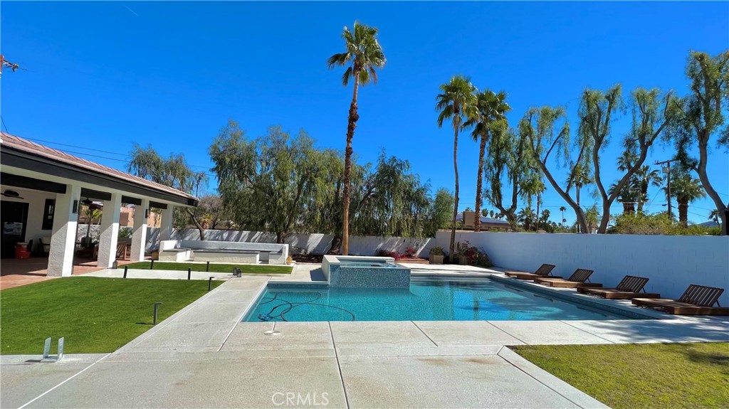 a view of swimming pool with palm trees