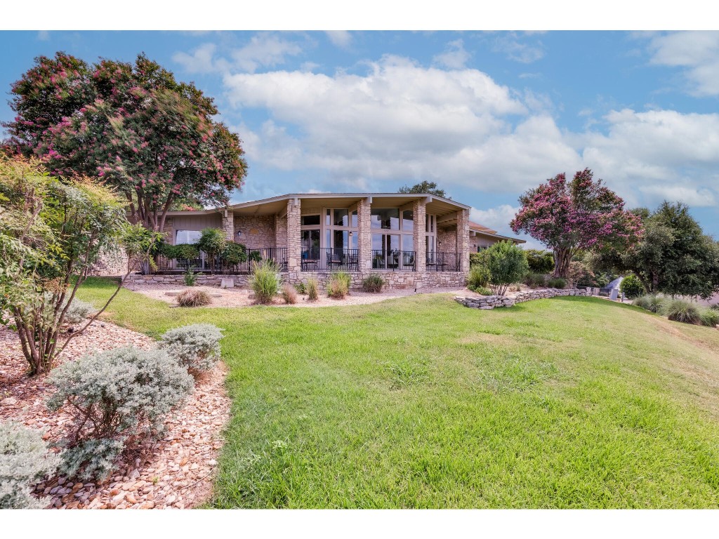 a view of a house with a big yard and potted plants