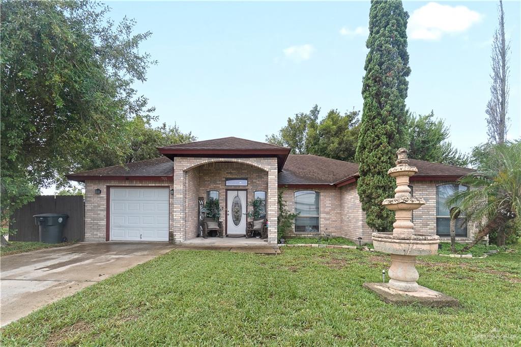 View of front facade featuring a front lawn and a garage