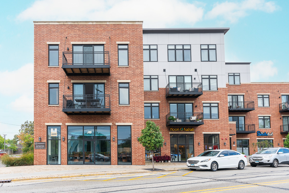 a front view of a residential apartment building with a yard