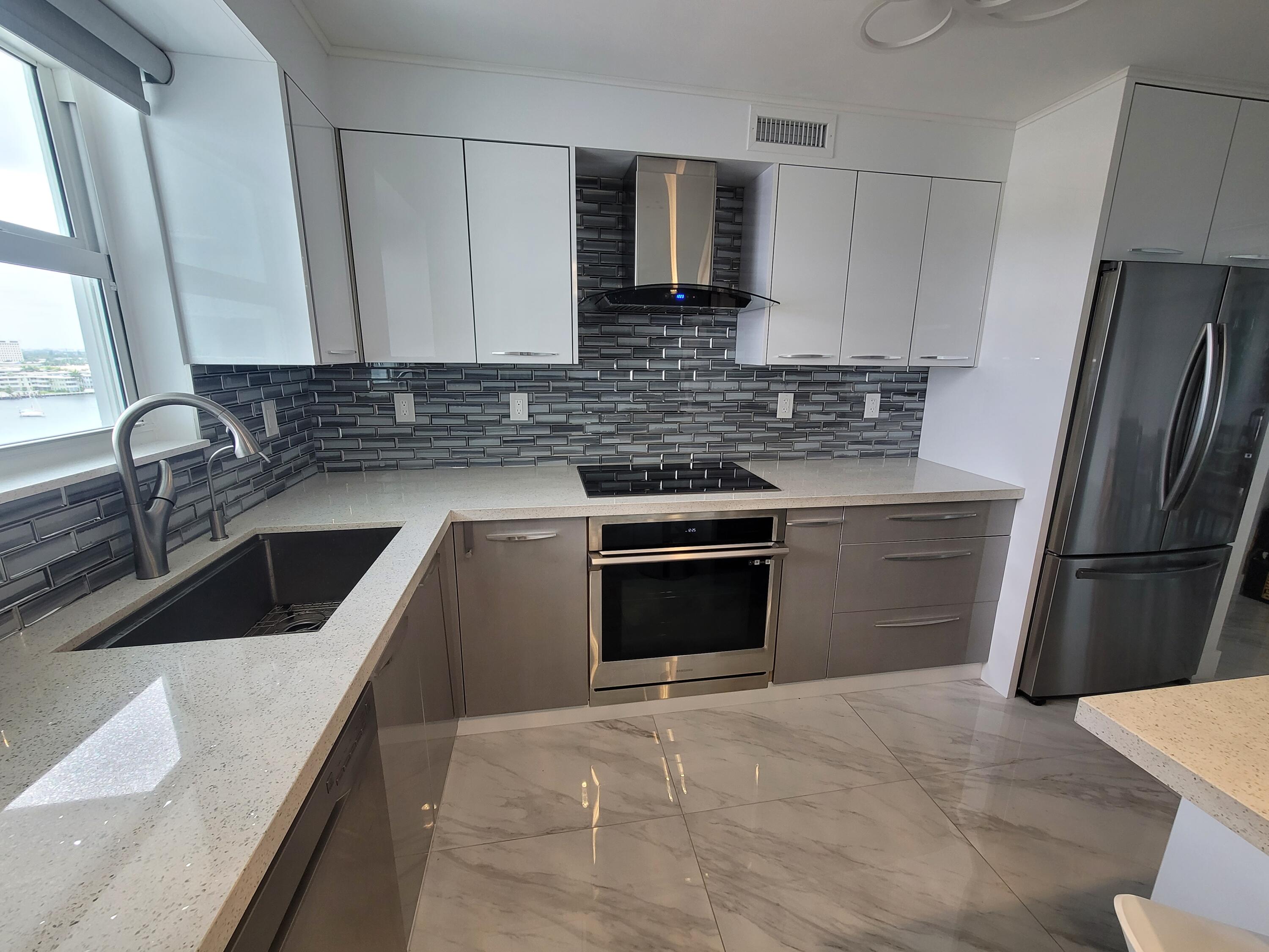 a kitchen with stainless steel appliances a sink stove and refrigerator