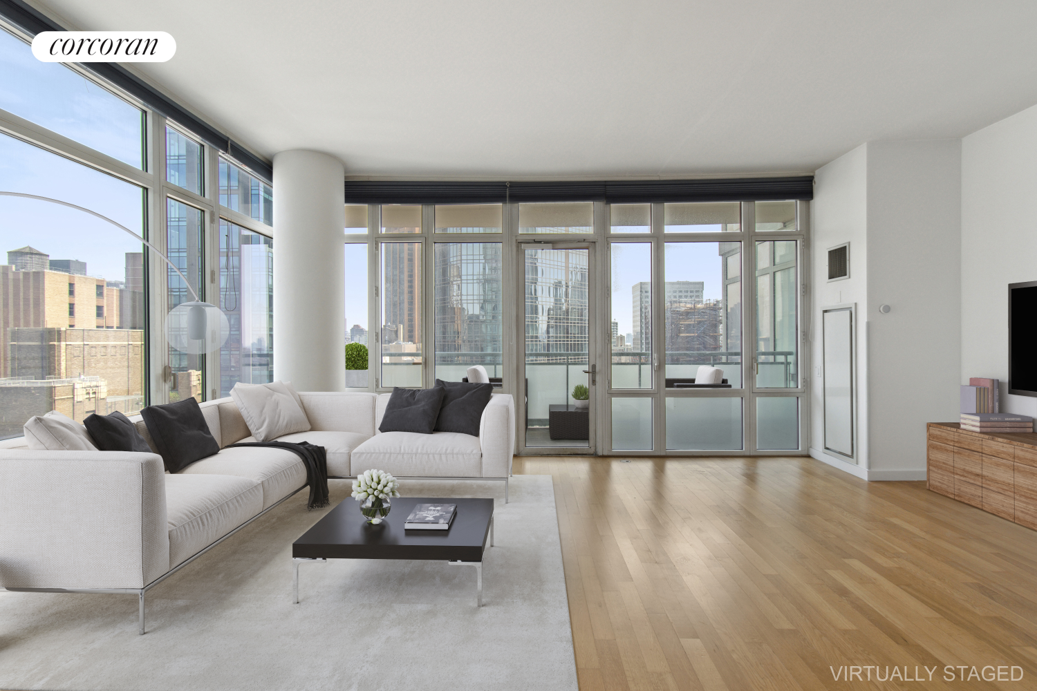 a living room with furniture large windows and wooden floor