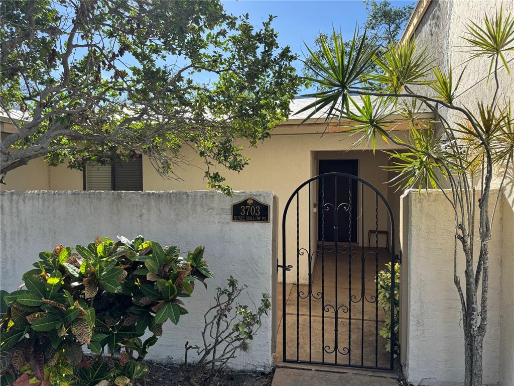 a front view of a house with a tree