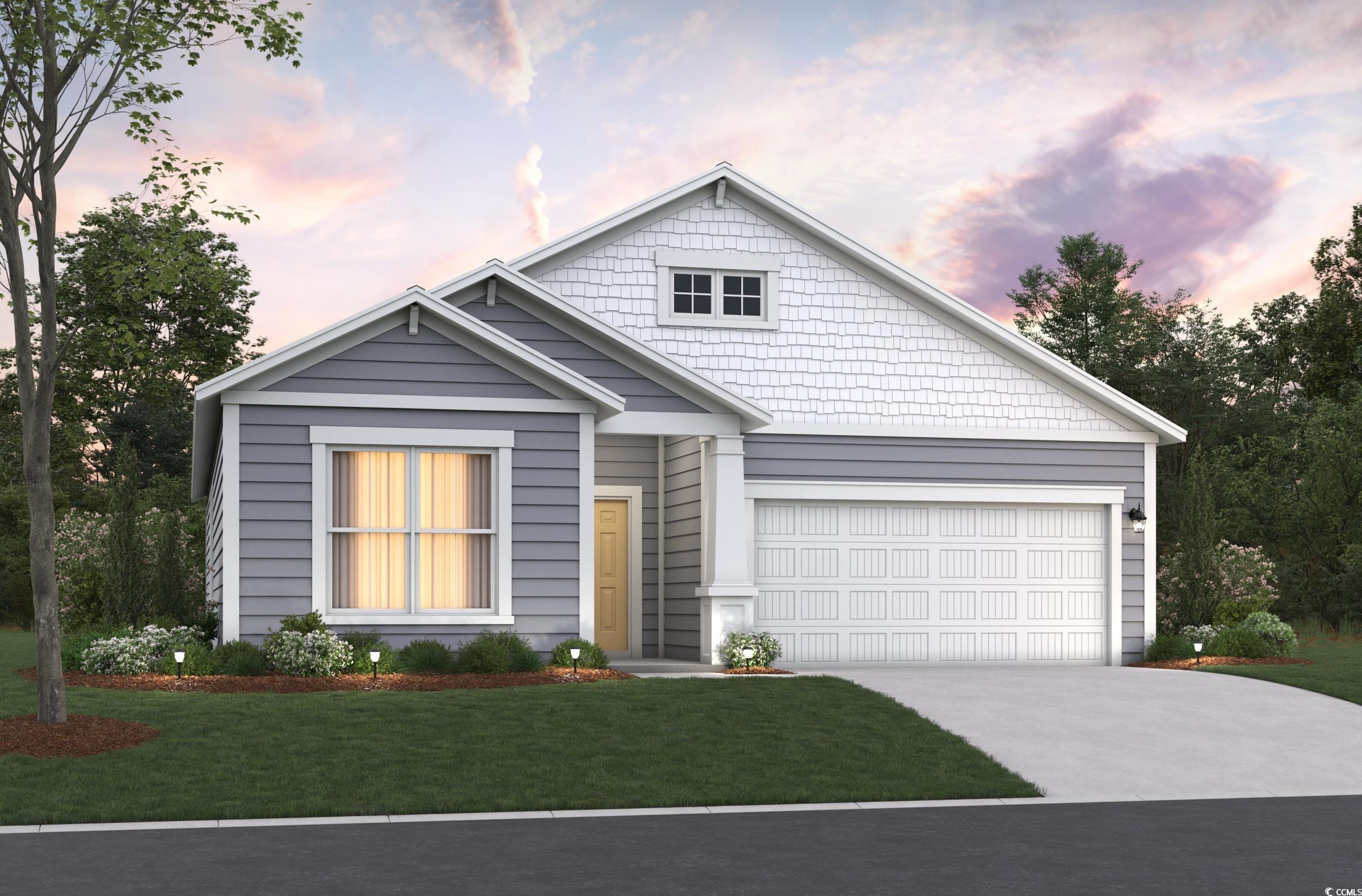 View of front facade featuring a lawn and a garage