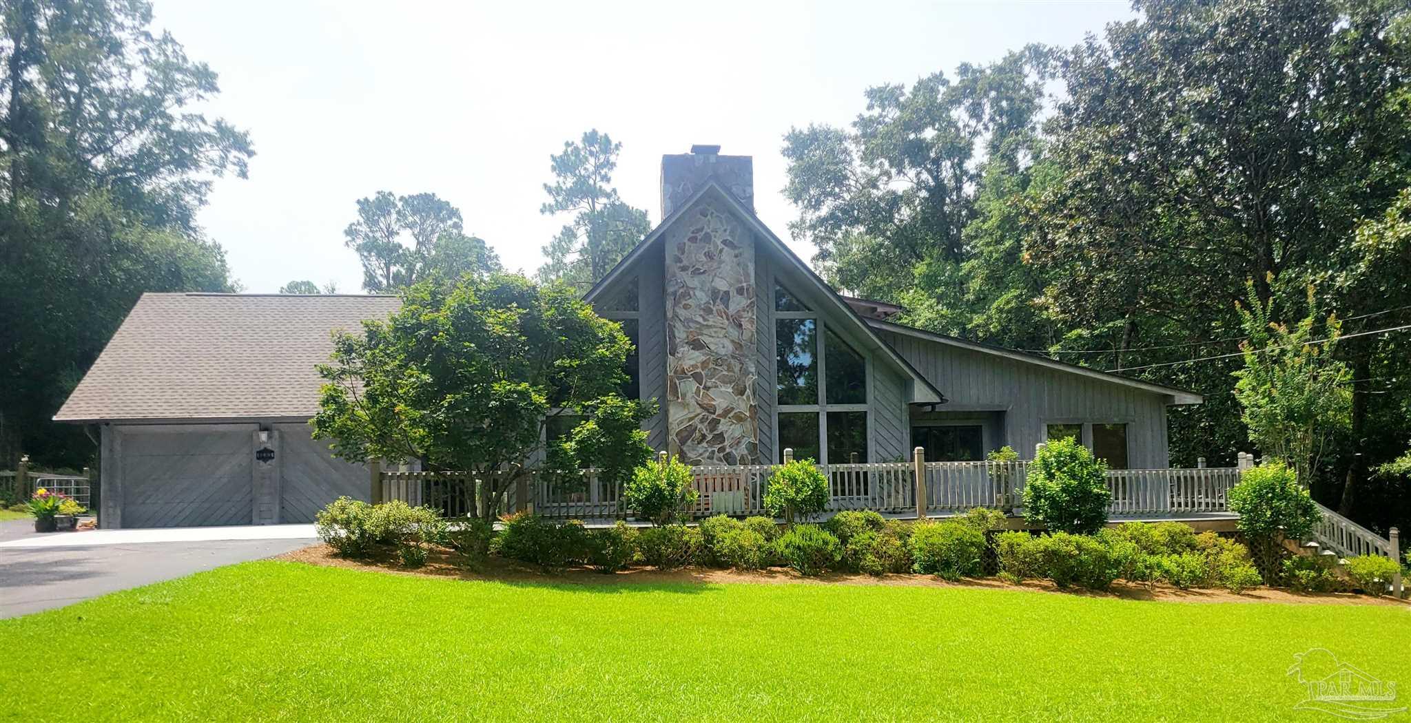 a front view of a house with a yard and potted plants