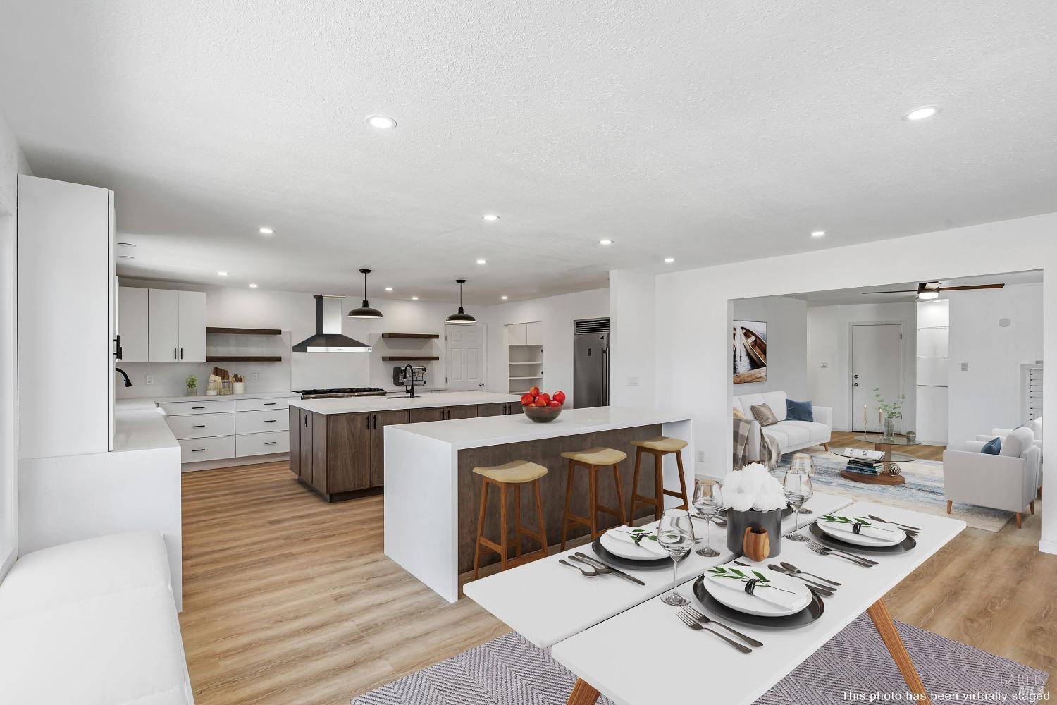 a kitchen with a sink a stove a kitchen island and chairs with wooden floor