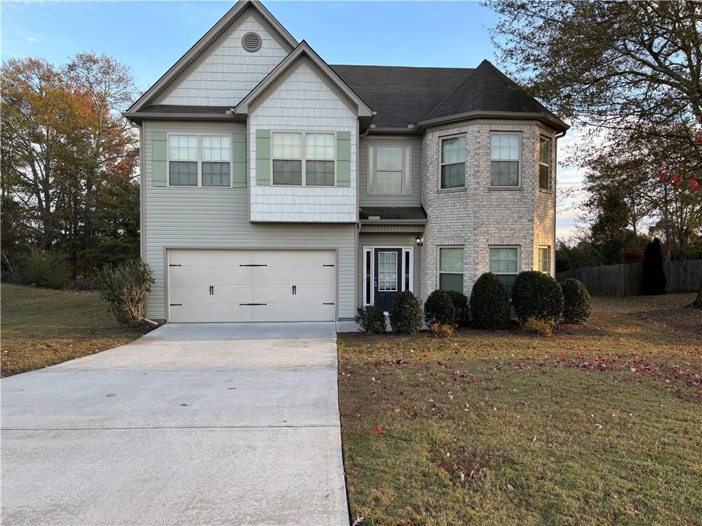 a front view of a house with a yard and garage