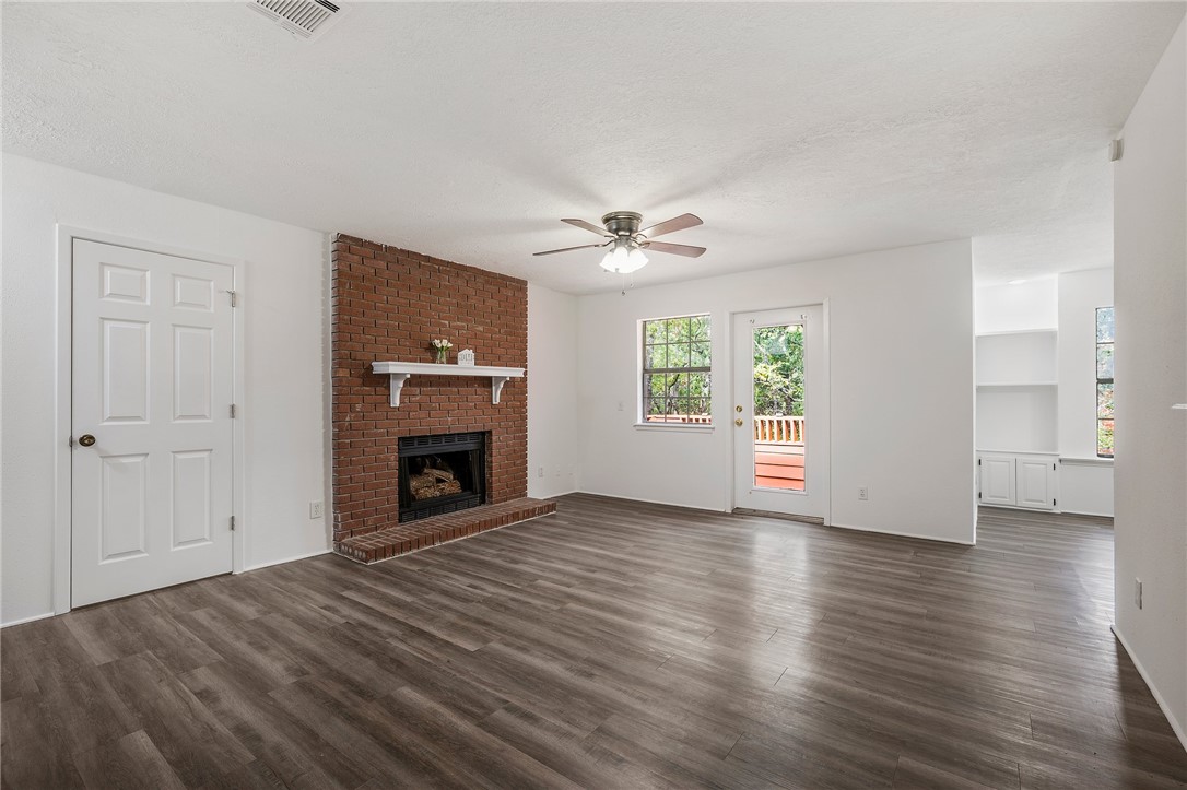 a view of an empty room with a window and fireplace