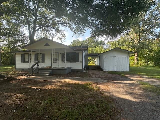 a view of a house with a yard and large tree