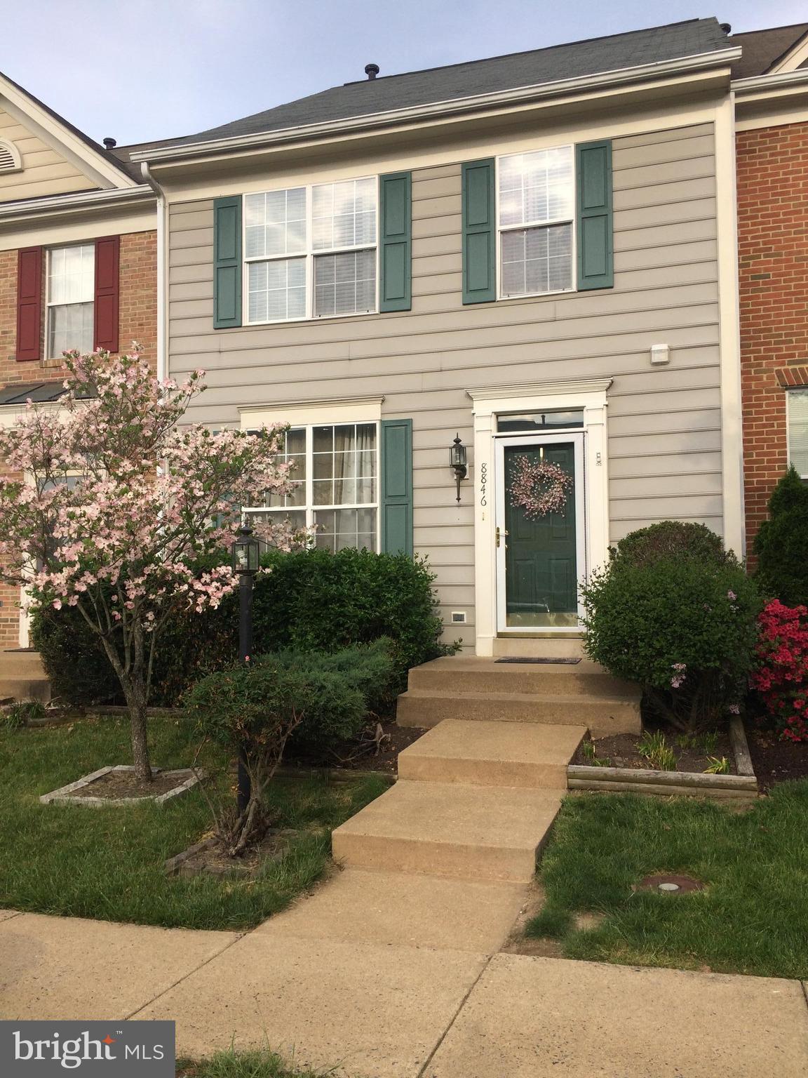 a front view of a house with a yard and a garden