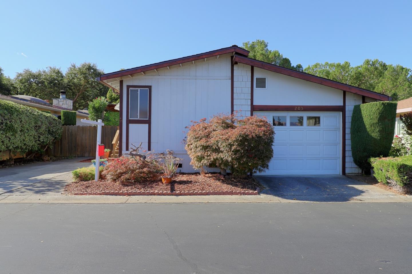 a front view of house with yard and trees in the background