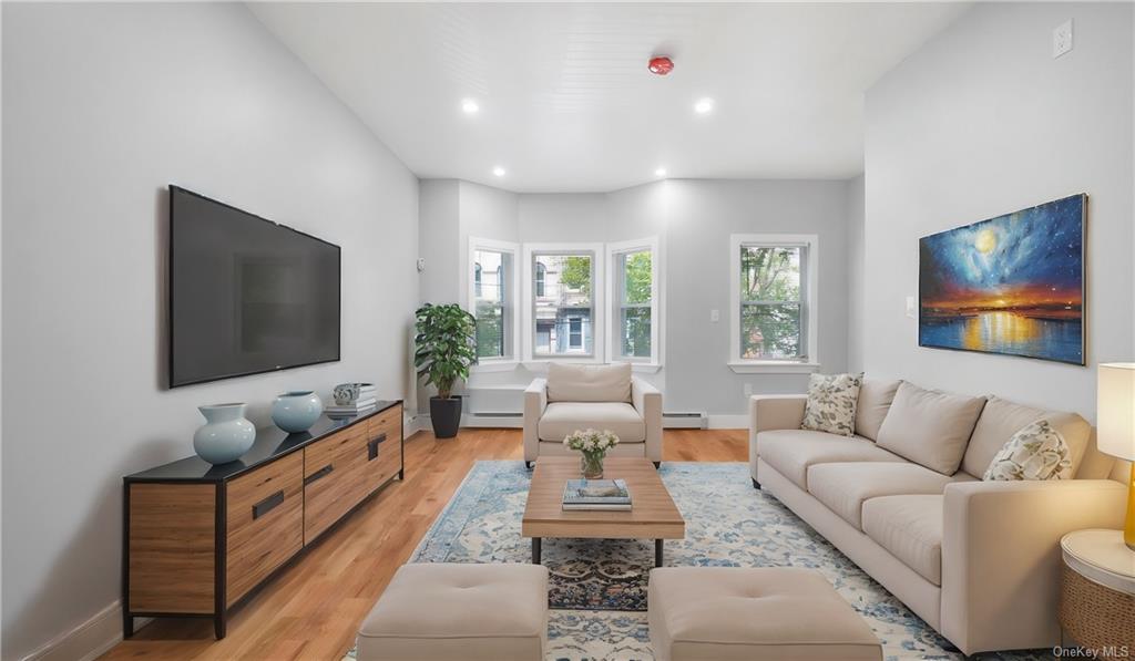 Living room featuring light hardwood / wood-style floors and a baseboard heating unit