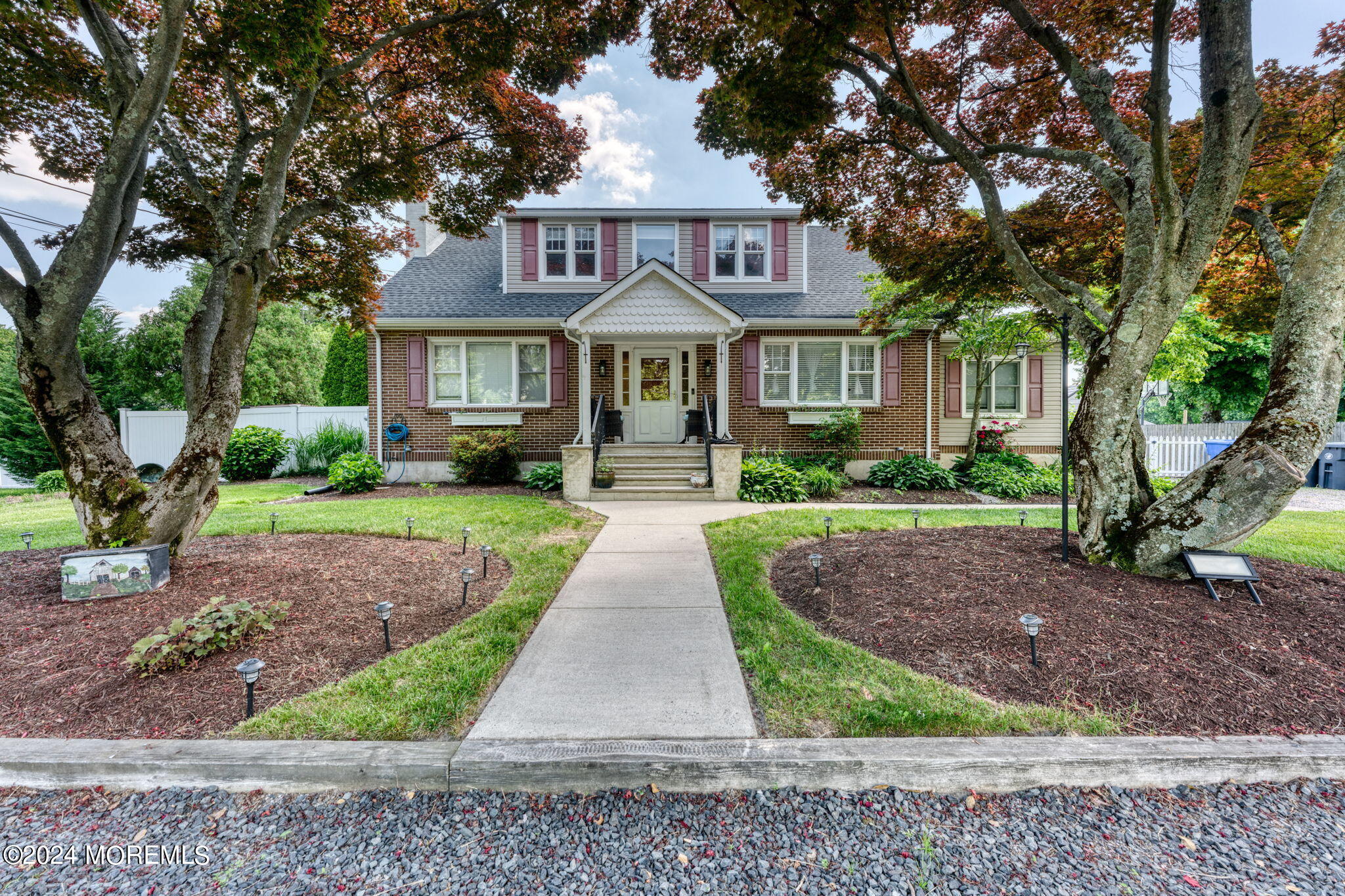 a front view of a house with yard and green space