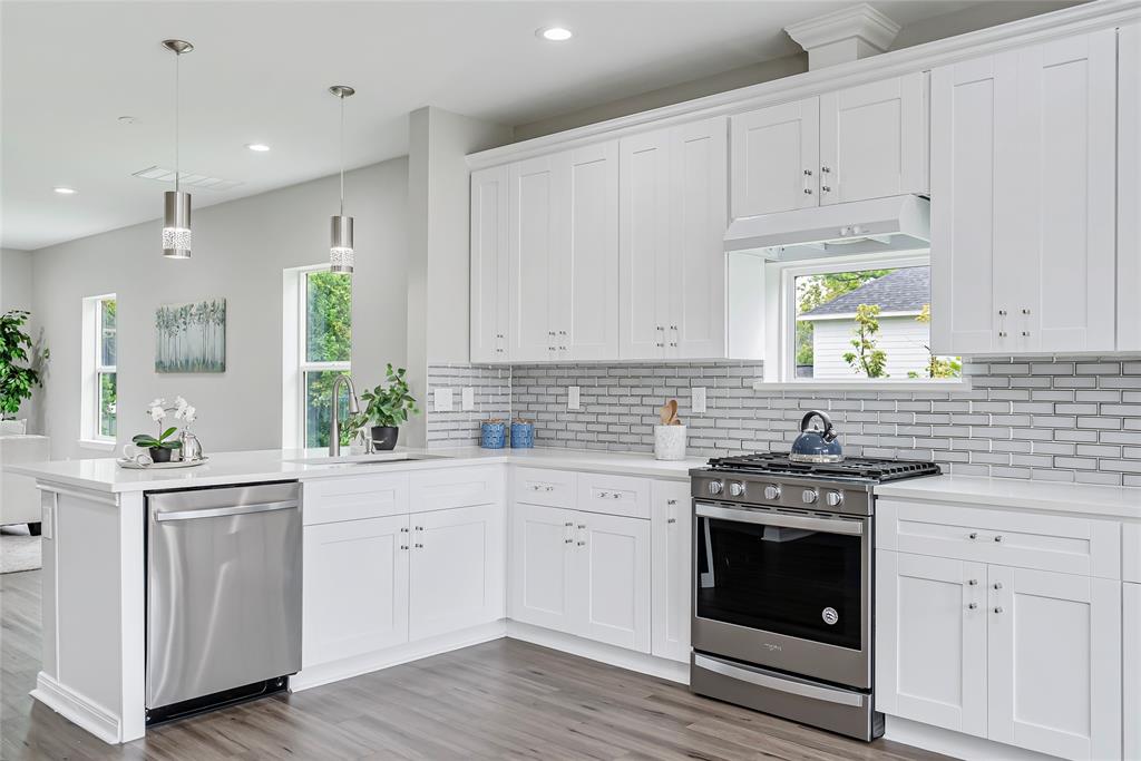 a kitchen with white cabinets stainless steel appliances and sink