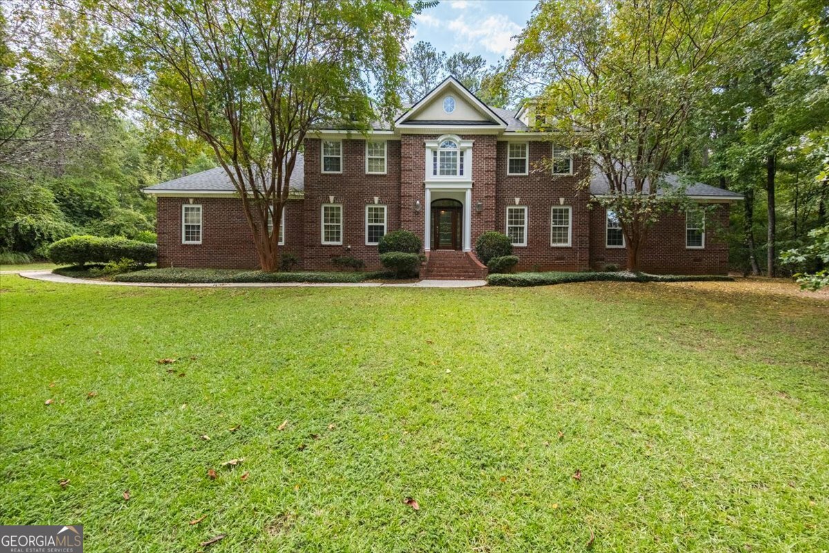 a front view of a house with a garden