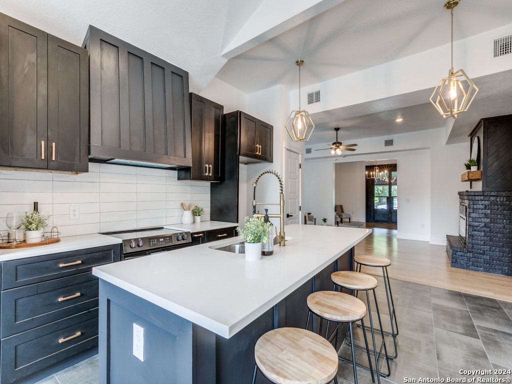 a kitchen with a sink a stove and chairs