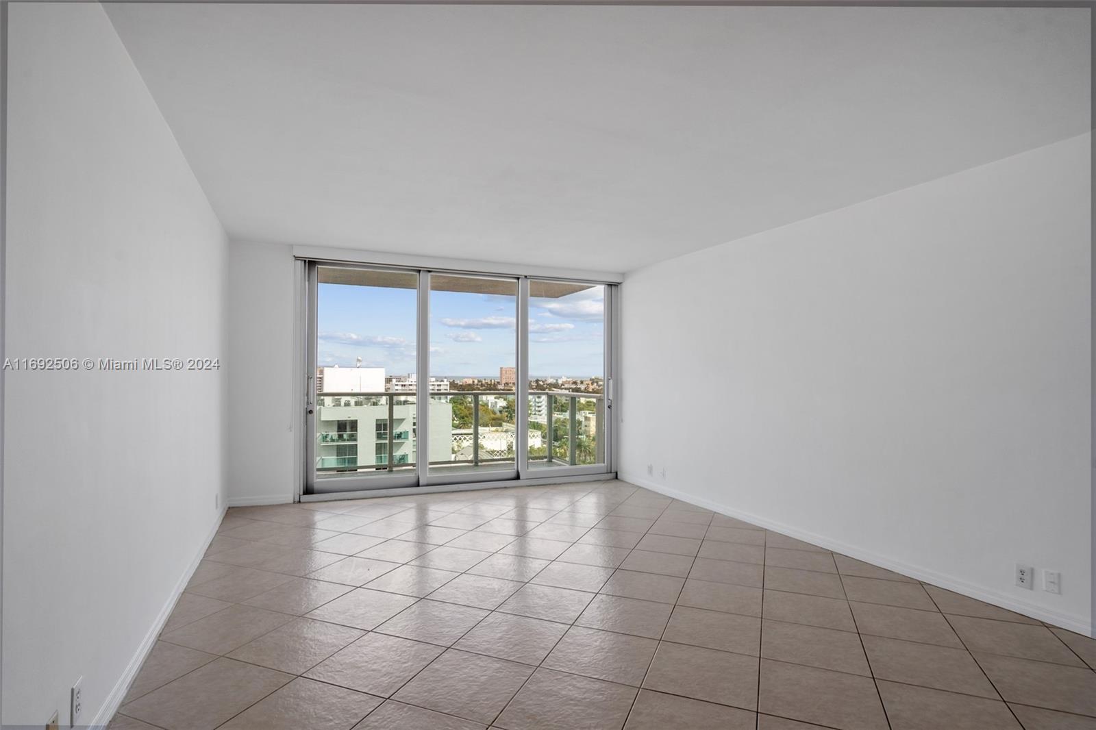 an empty room with floor to ceiling window and an outdoor space