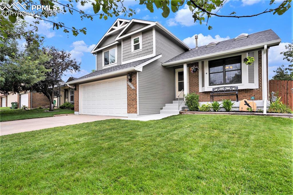 a front view of a house with a garden and yard