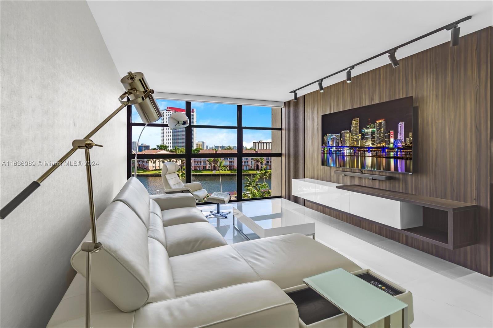 a living room with furniture a rug and a floor to ceiling window