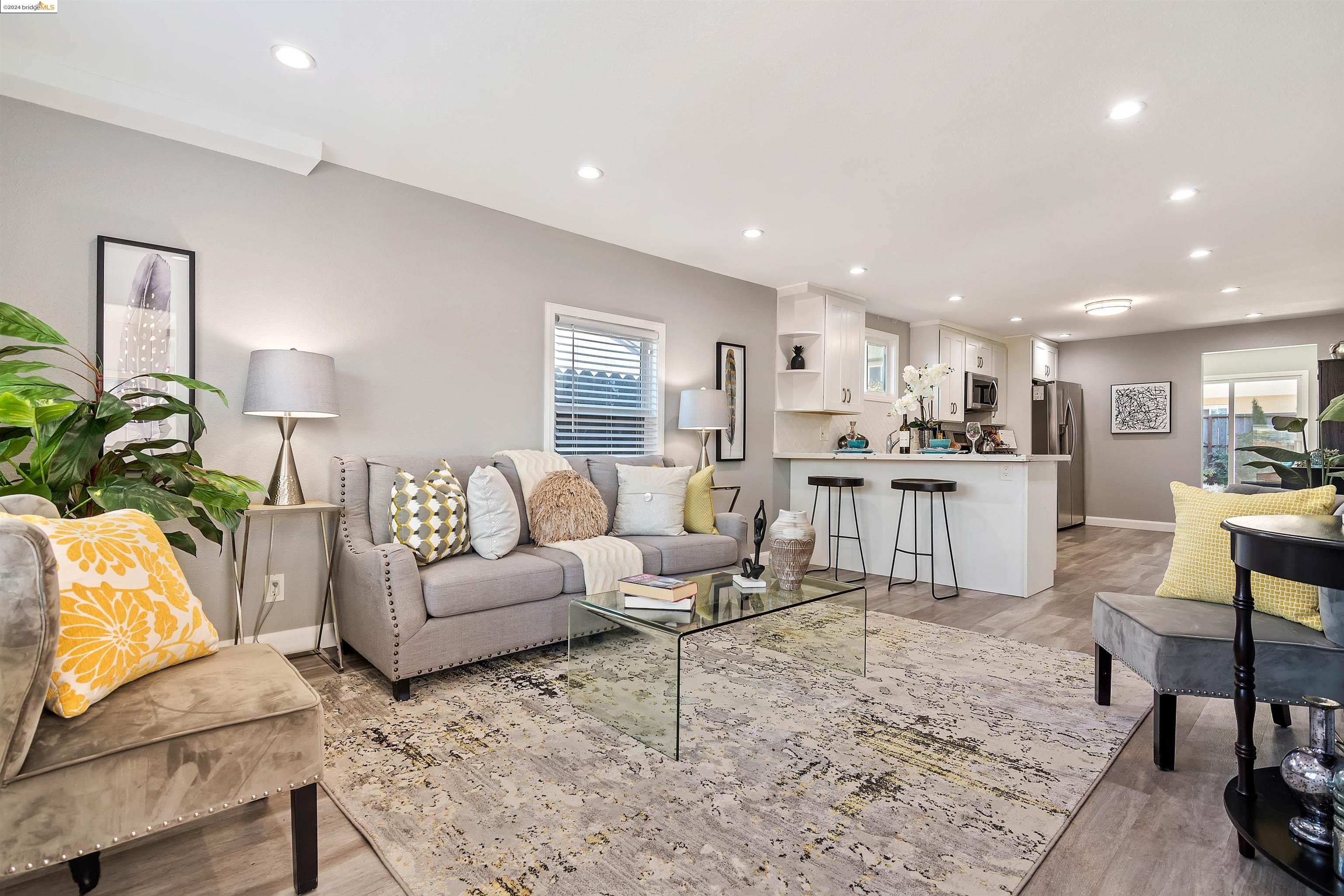 a living room with furniture and kitchen view