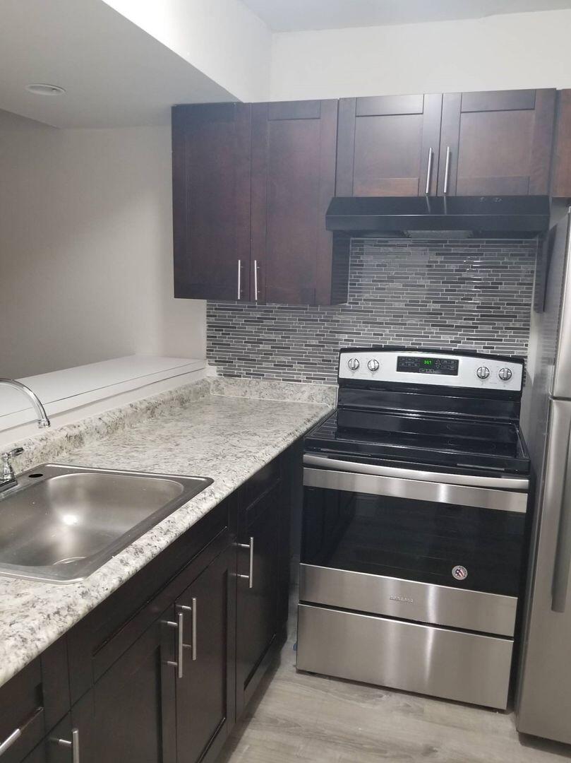 a close view of stove a sink and dishwasher in a kitchen