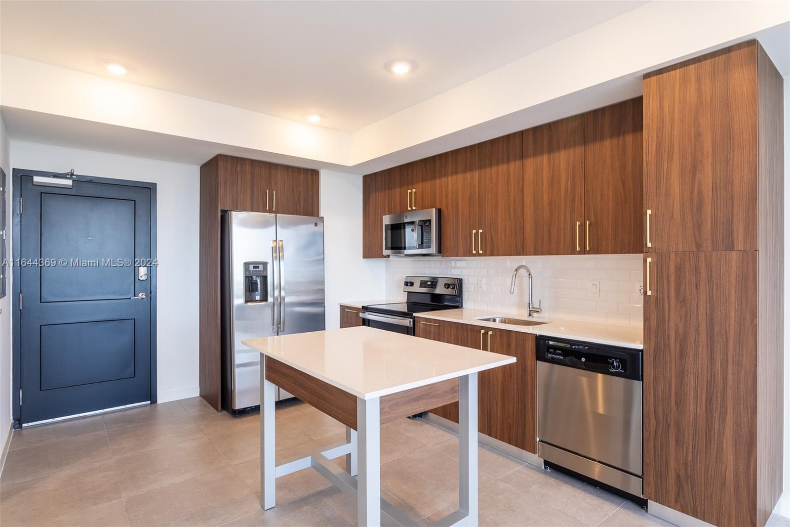 a kitchen with a sink a stove a refrigerator and cabinetry