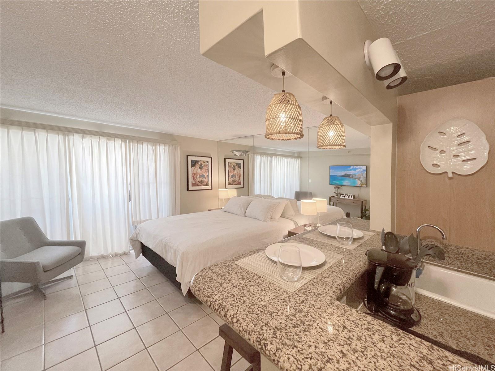 a spacious bedroom with a bed a chandelier and mirror