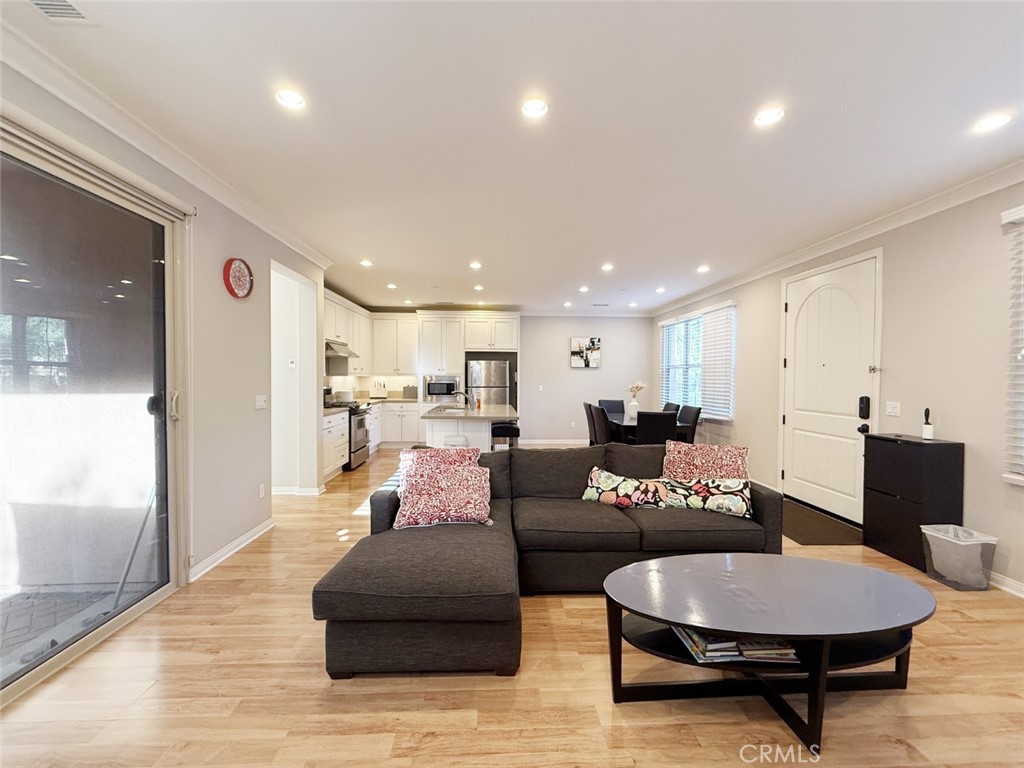 a living room with furniture and a view of kitchen