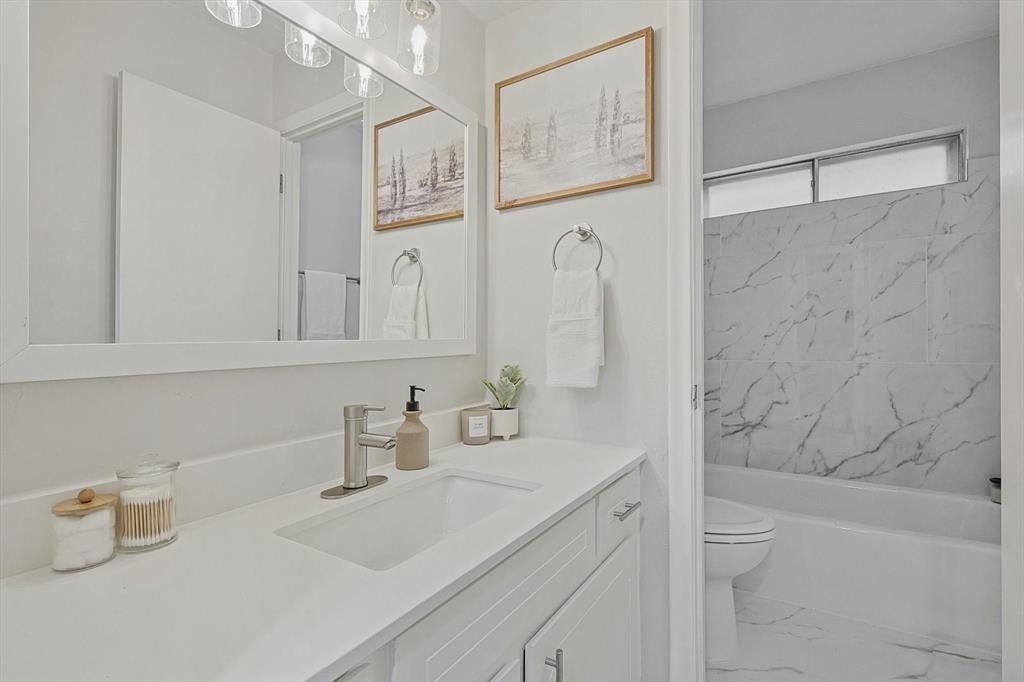 a bathroom with a sink vanity granite tub and shower