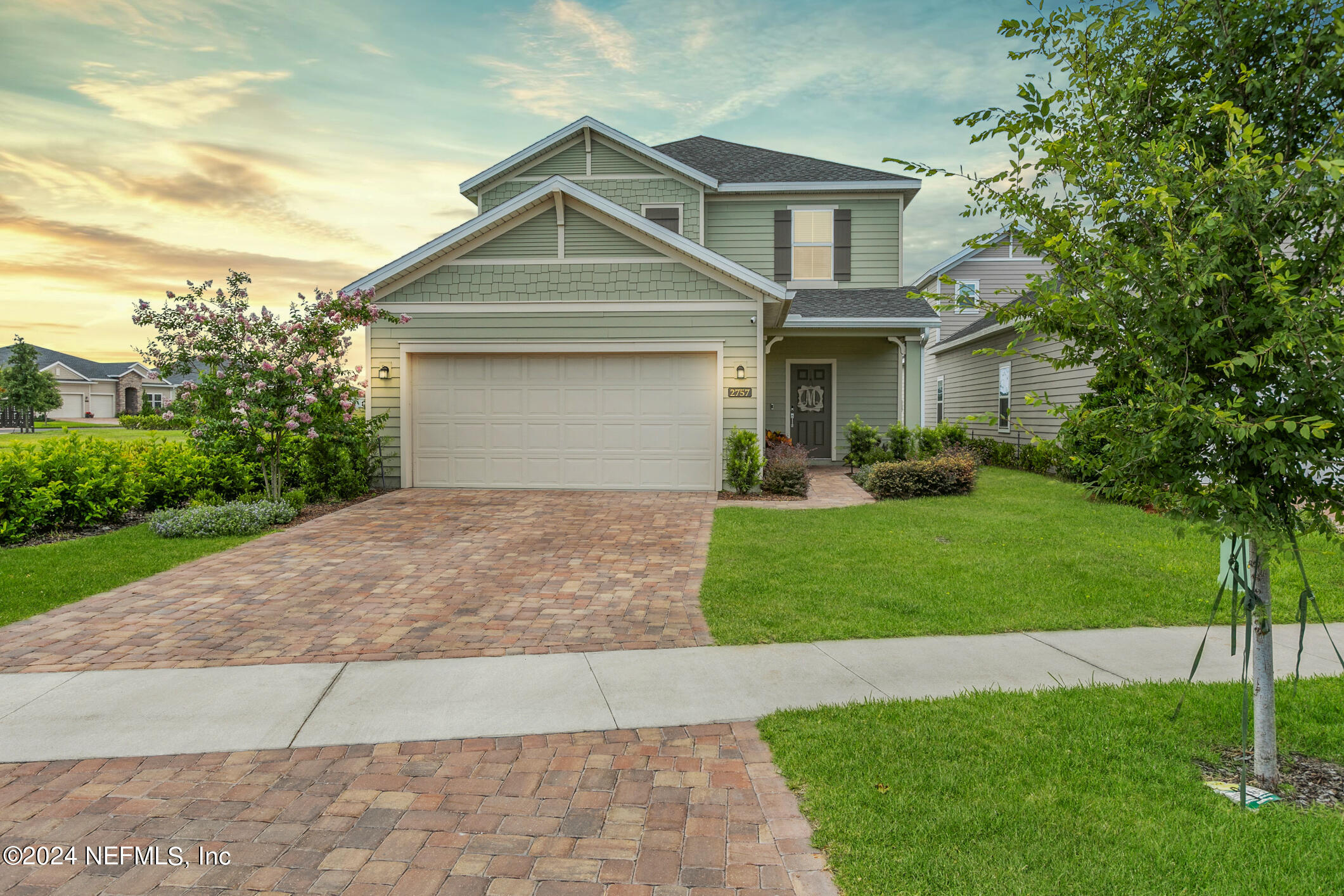 a front view of a house with a yard and trees