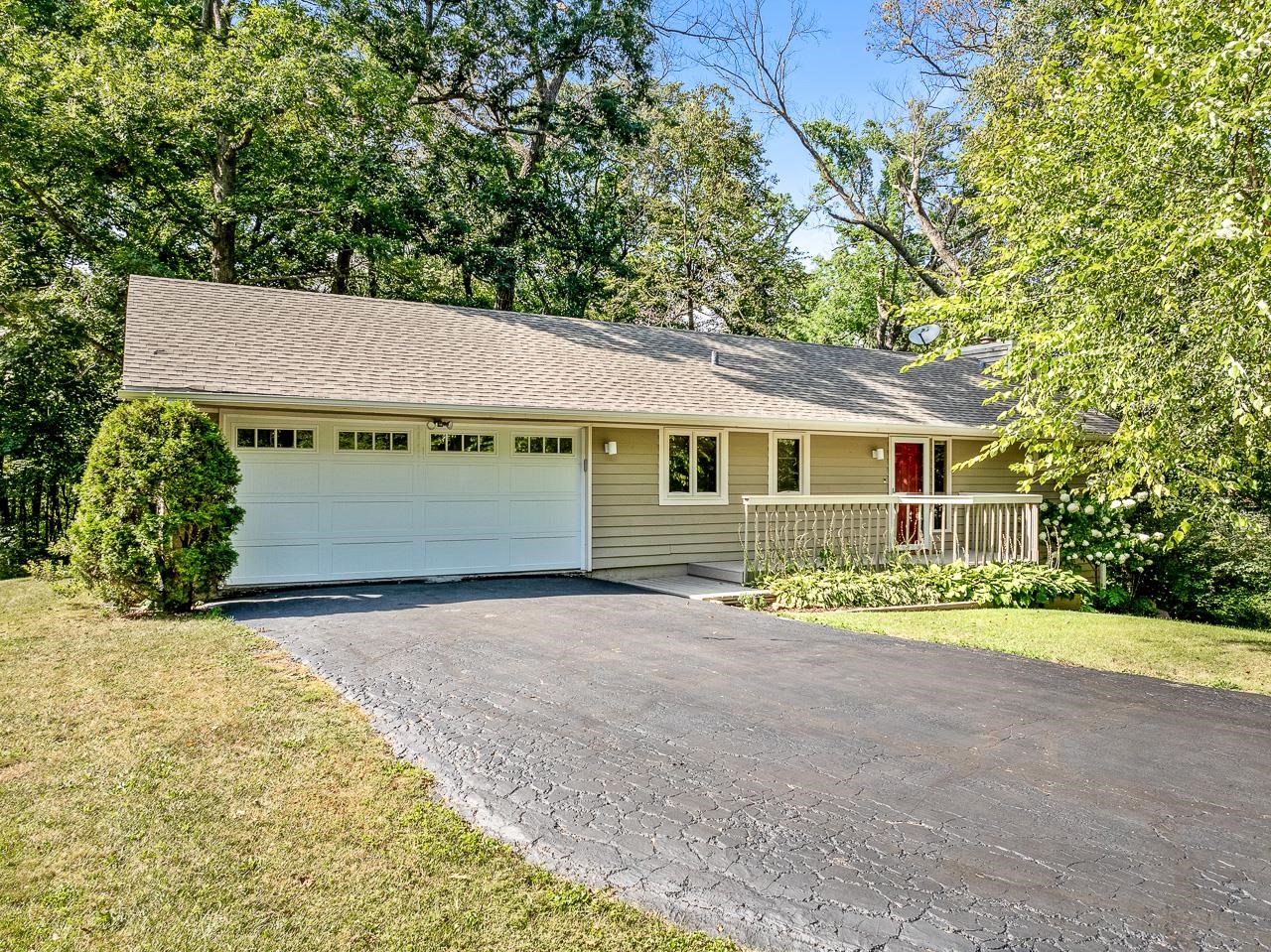 a front view of a house with a yard and potted plants