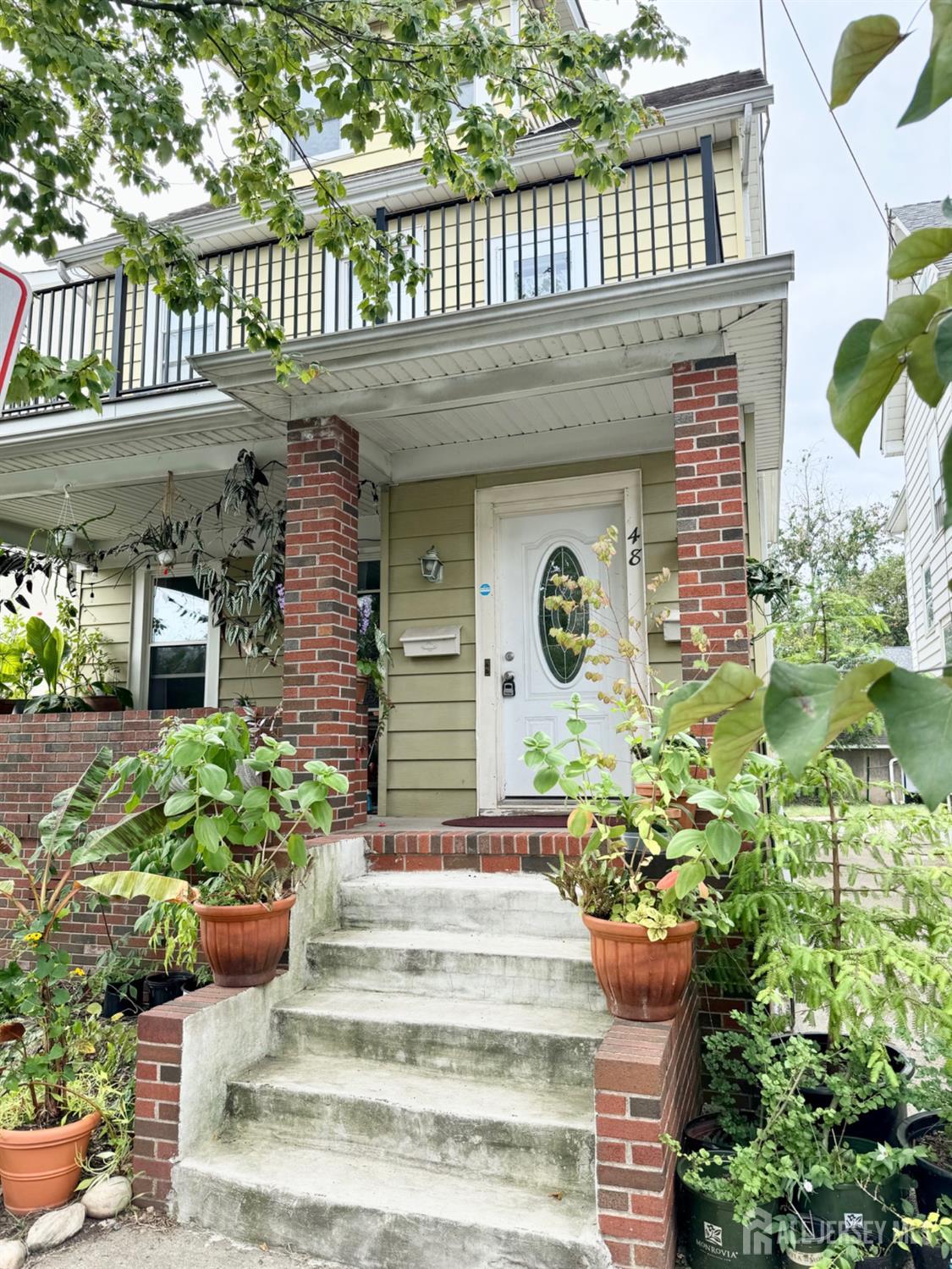 a front view of a house with plants