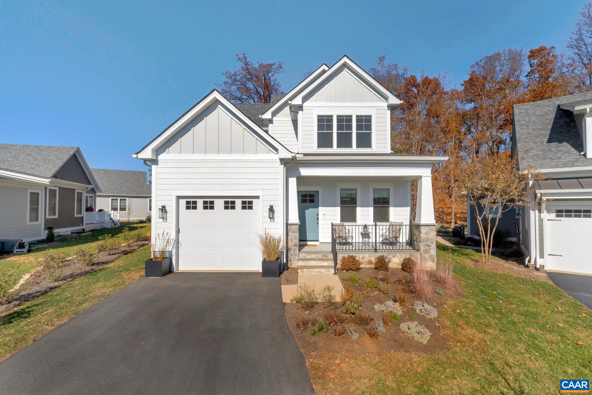 a front view of a house with a yard outdoor seating and garage