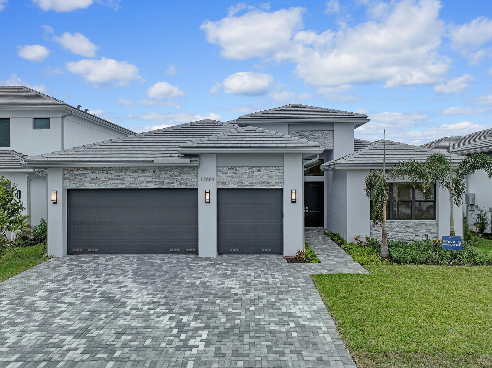 a front view of a house with a garden and yard