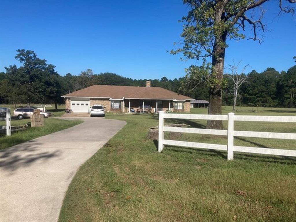 a view of house with outdoor space and trees