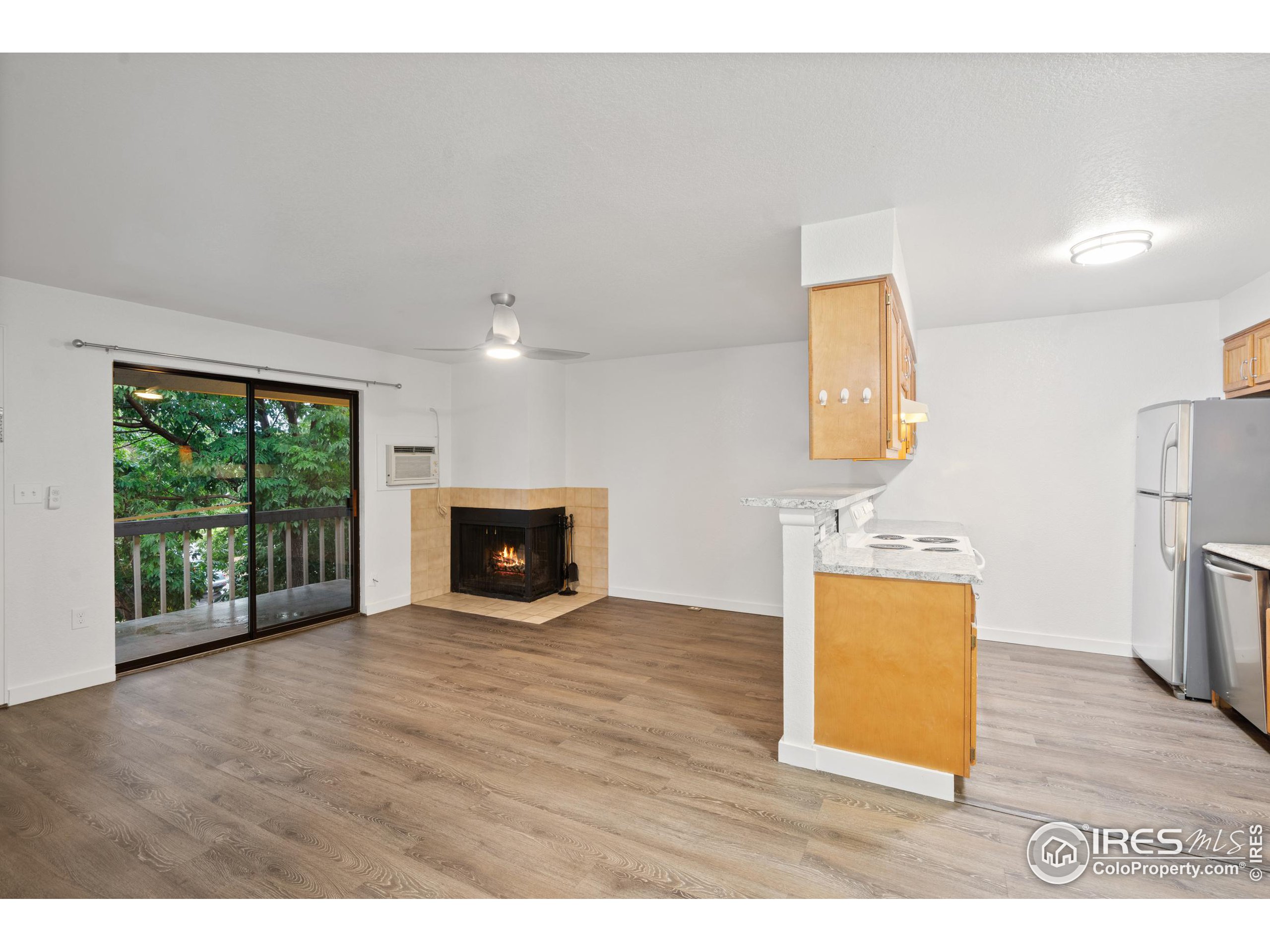 a view of an empty room with a fireplace and a window