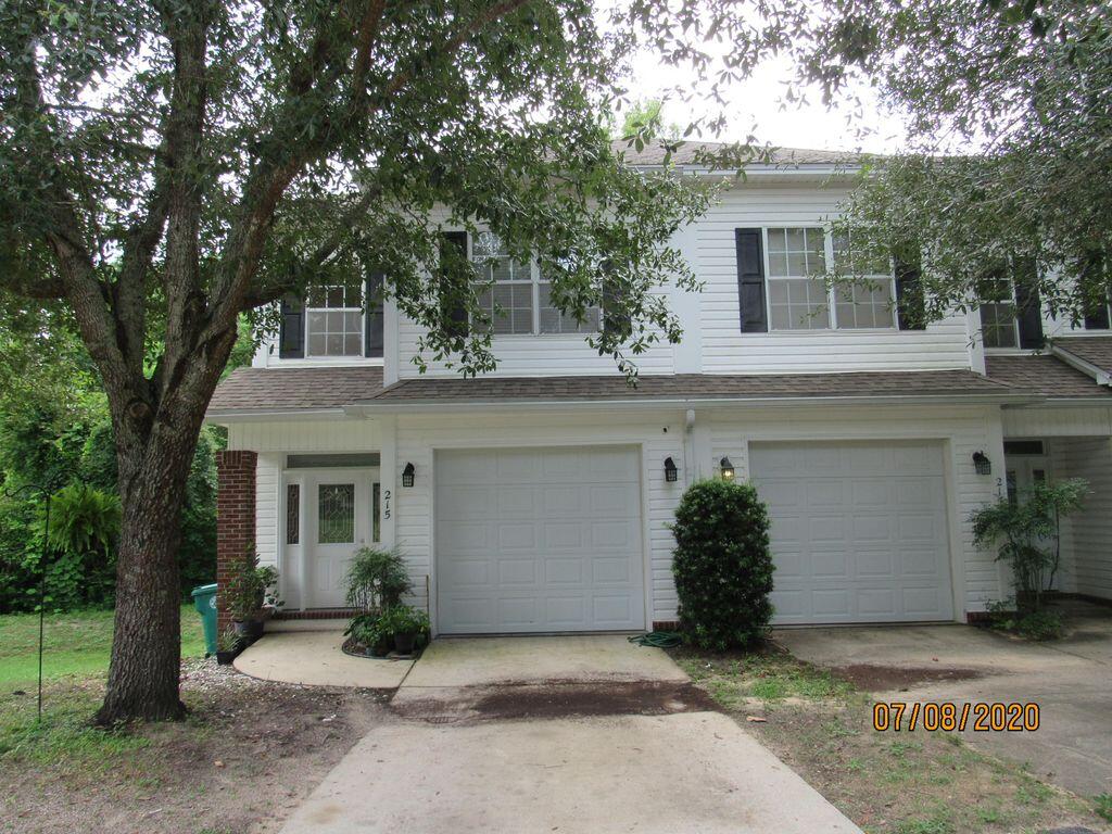 a view of a house with a yard and large tree