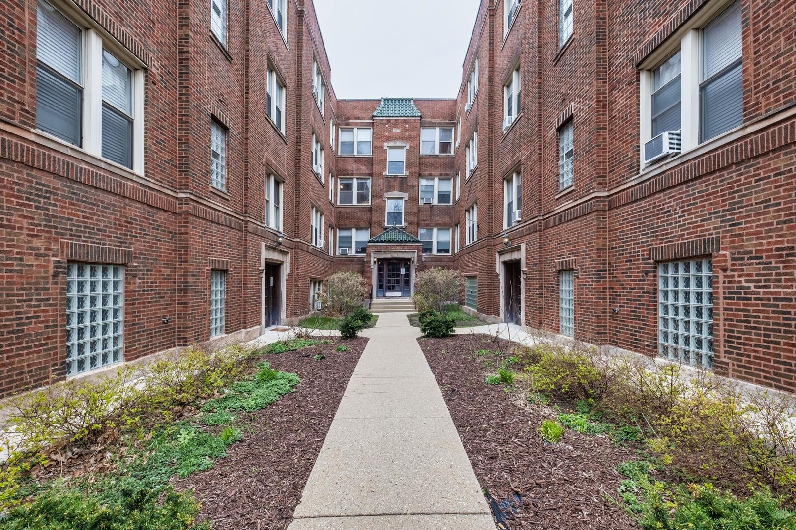 a view of a brick building next to a yard