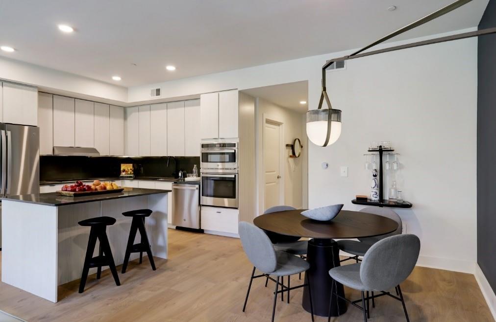 a kitchen with a table chairs refrigerator and cabinets