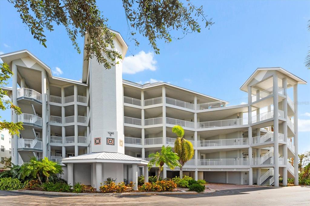 a front view of a building with a garden and plants