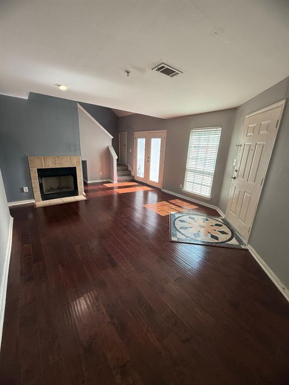 a view of empty room with wooden floor and window