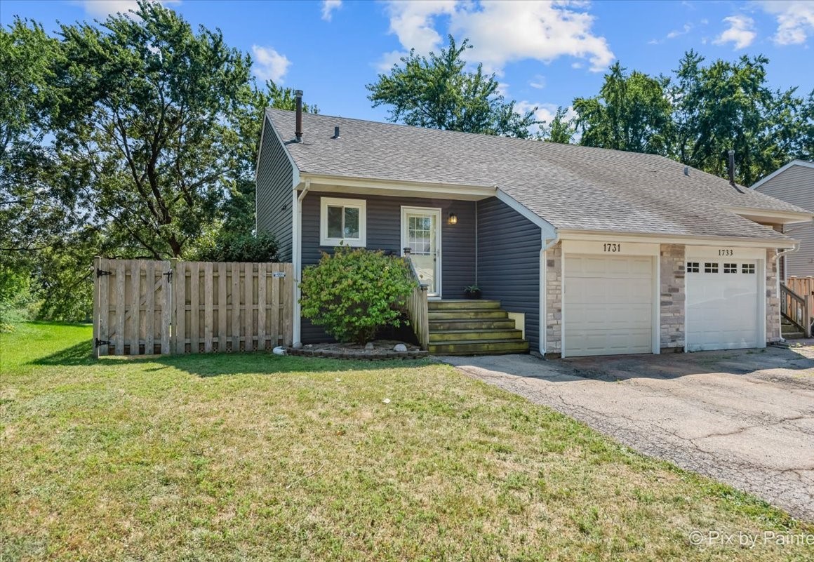 a view of a house with a yard and garage